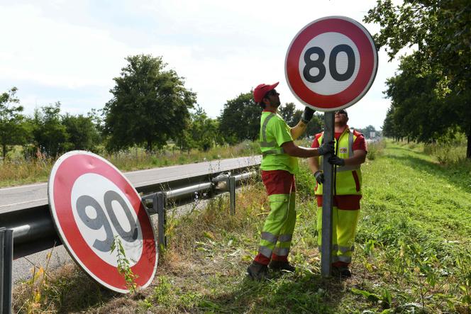 Des employés de la direction interdépartementale des routes de l’Est remplacent un panneau de limitation de vitesse à 90 km/h par un panneau à 80 km/h sur une route à Wittenheim (Haut-Rhin), en juin 2018.