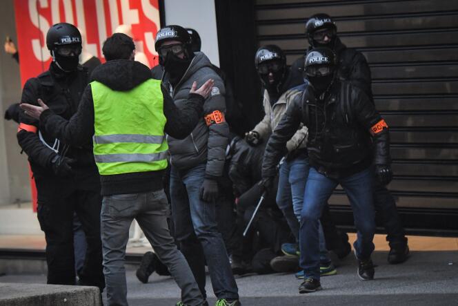 Un « gilet jaune » face aux policiers de la BAC lors de l’interpellation d’un manifestant, à Paris, le 12 janvier.