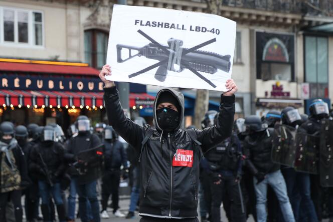 Un manifestant porte une pancarte dénonçant l’usage du lanceur de balles de défense  (LBD40) lors des manifestations, pendant l’acte XII des « gilets jaunes » à Paris, samedi 2 février 2019.