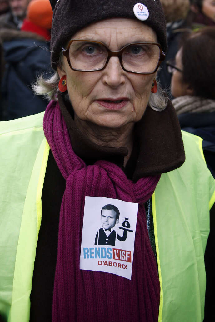 L’autocollant « Rends l’ISF d’abord » sur le gilet jaune d’une manifestante à Paris, le 5 février.
