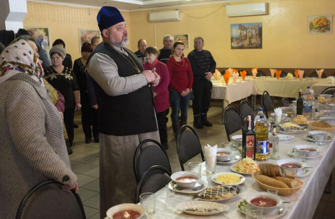 Le père Iaroslav (patriarcat de Kiev) et ses paroissiens prient avant un déjeuner commémoratif. Desna (Ukraine), le 2 février 2019.