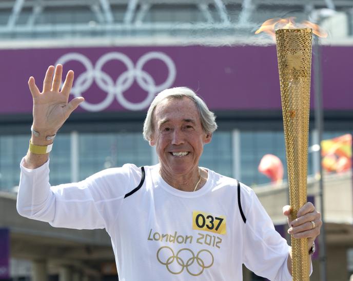 Sur cette photo prise le 25 juillet 2012, l’ancien gardien de but international anglais Gordon Banks porte le flambeau olympique devant le stade de Wembley, deux jours avant le début des Jeux olympiques de Londres 2012.
