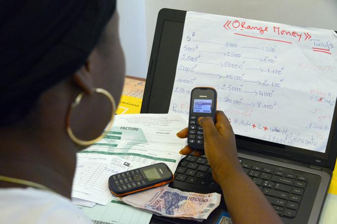 Une salariée de la société Orange Money paie une facture depuis un compte de téléphone mobile, en mai 2015, à Abidjan.