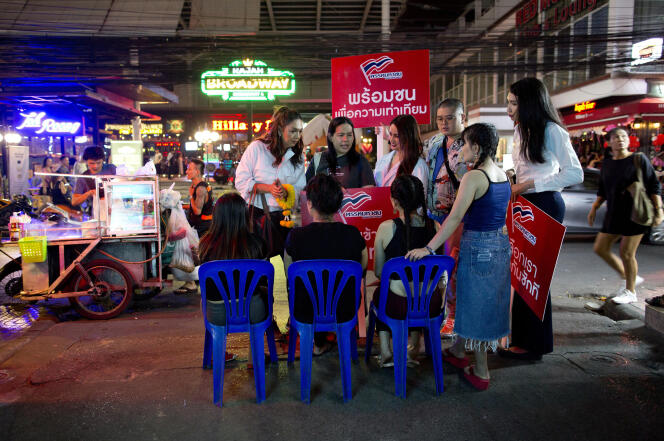 Pauline Ngarmpring discute avec des travailleurs d’un salon de massage en bordure de route à Bangkok (Thaïlande), le 13 février.