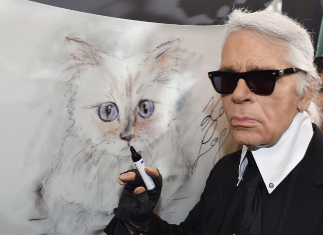 Le créateur de mode, artiste et photographe allemand Karl Lagerfeld à côté d’une peinture de son chat Choupette lors de l’inauguration de l’exposition « Corsa Karl et Choupette » au Palazzo Italia à Berlin.