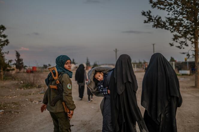 Une combattante des Forces démocratiques syriennes accompagne deux femmes de djihadistes dans le camp d’Al-Hawl, au nord-est de la Syrie, le 17 février.