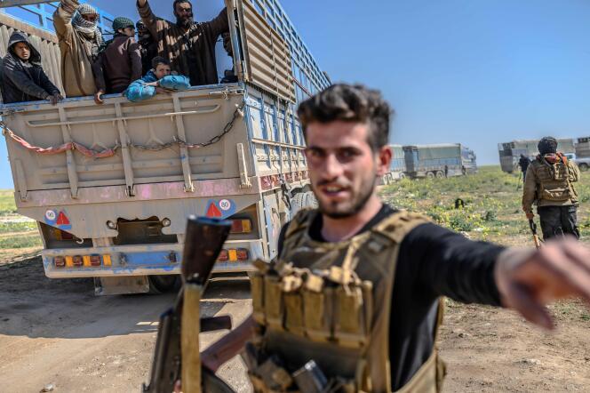 Un membre des Forces démocratiques syriennes surveille des personnes suspectées d’être des combattants de l’Etat islamique, près de Al-Baghouz, le 20 février.