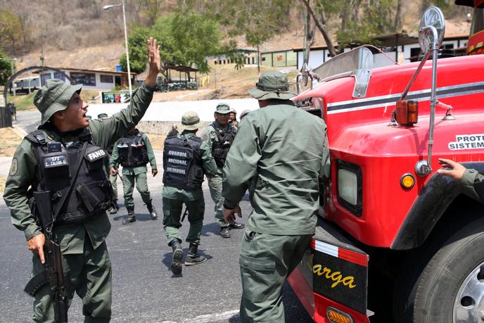 Des représentants des forces de sécurité bloquent la route où veulent passer des parlementaires de l’opposition avec leurs partisans, à proximité de Mariara, Venezuela, le 21 février 2019.