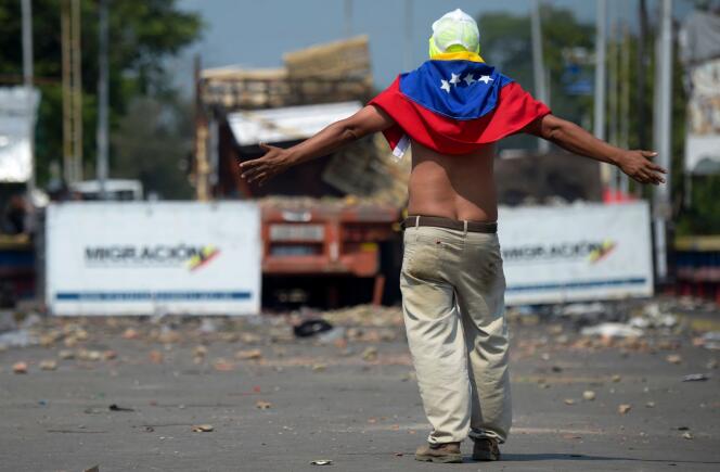 Un manifestant, à Cucuta (Colombie), devant les forces de sécurité vénézuéliennes qui bloquent le pont Paula Santander menant au Venezuela.