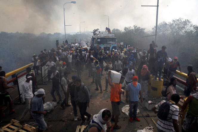 Des vivres sont déchargés d’un camion incendié, après des heurts avec les forces de sécurité vénézuéliennes, à la frontière colombienne, le 23 février.