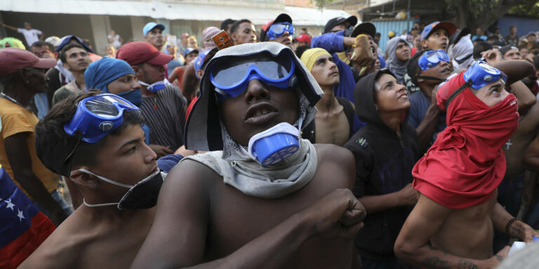 Venezuelan migrants under the Simon Bolivar International Bridge plead for people to support them with food and water so they can continue protesting in La Parada near Cucuta, Colombia, Sunday, Feb. 24, 2019, on the border with Venezuela. A U.S.-backed drive to deliver foreign aid to Venezuela on Saturday met strong resistance as troops loyal to President Nicolas Maduro blocked the convoys at the border and fired tear gas on protesters. (AP Photo/Fernando Vergara)