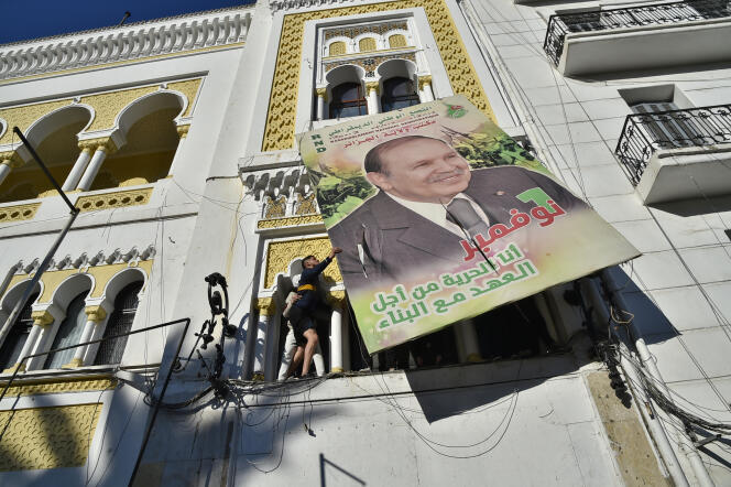 Des manifestants décrochent un portrait d’Abdelaziz Bouteflika, à Alger, le 22 février 2019.