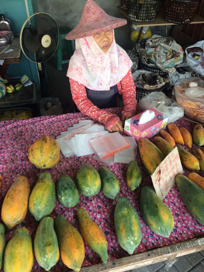 Vendeuse de papayes et sa coiffe traditionnelle, à Tainan.