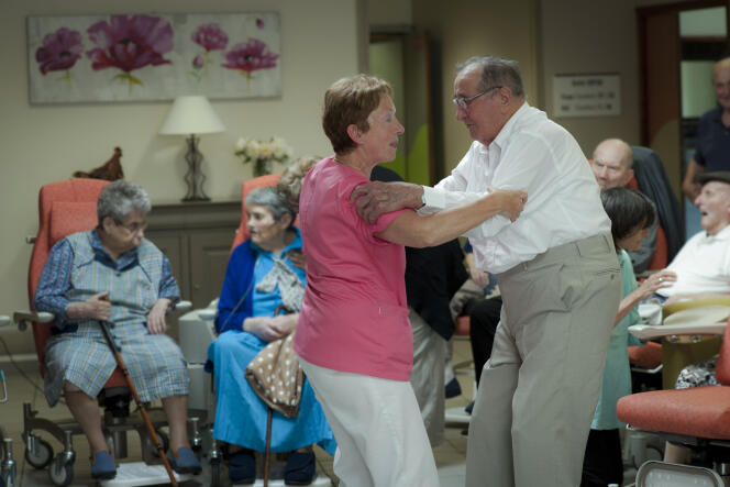 Une soignante aide un résident et le fait danser, dans un Ehpad à Ally (Cantal), en 2013.