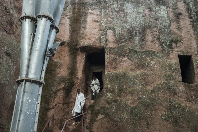 Des Ethiopiens orthodoxes sortent de l’église Amanuel, à Lalibela, près d’un des piliers soutenant le toit qui protège l’édifice des intempéries, le 7 mars 2019.