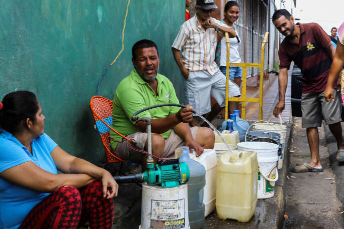 Des Vénézuéliens se regroupent autour des alimentations d’eau pour remplir des bidons. Le 12 mars 2019 à San Felix.