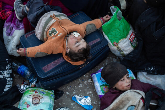 Dehors devant les tentes, deux enfants ayant fui Baghouz dorment parmi les centaines de civils arrivés au camp d’ Al Hawl.