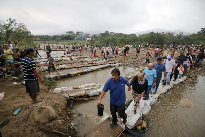 Des Vénézuéliens quittant le pays, en passant la rivière Tachira à la frontière avec la Colombie, le 12 mars 2019.