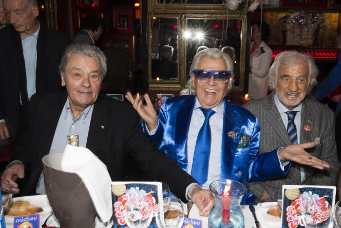 Michou entouré de Jean-Paul Belmondo et Alain Delon, le 20 juin 2016 à Paris.