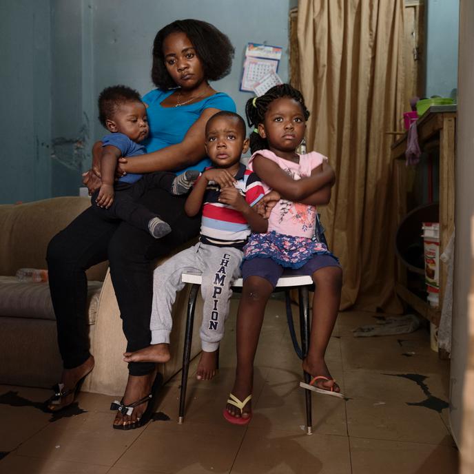 Angelica Nsoso et ses enfants Kissalu, Felipe et Jeouany dans leur appartement de l'occupation 9 de julho  quartier Bela Vista à Sao Paulo au Brésil. Famille Angolaise réfugiée au Brésil. Angelica est arrivée enceinte au Brésil 1 an plus tôt, à la maison des immigrants, un centre catholique de Sao paulo, ils arrivent de Luanda ( Angola) et sont réfugiés. Des brigands se sont introduits chez eux et ont menacés de violer Kissalu si ils ne donnaient pas tout l’argent. La famille a tout perdu ou presque ce jour là.