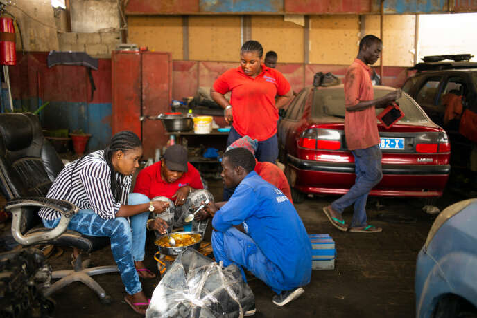 En banlieue de Dakar, l’équipe du garage Femme Auto, à parité femmes-hommes, déjeune ensemble.