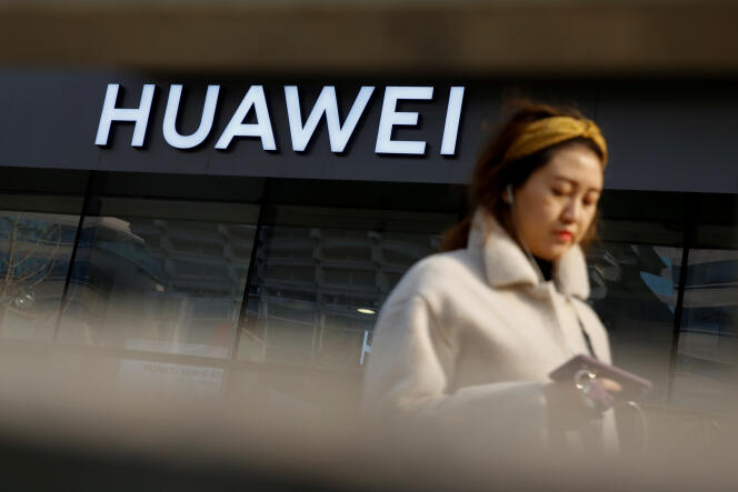 Une femme passe devant une boutique Huawei à Pékin, le 29 janvier.