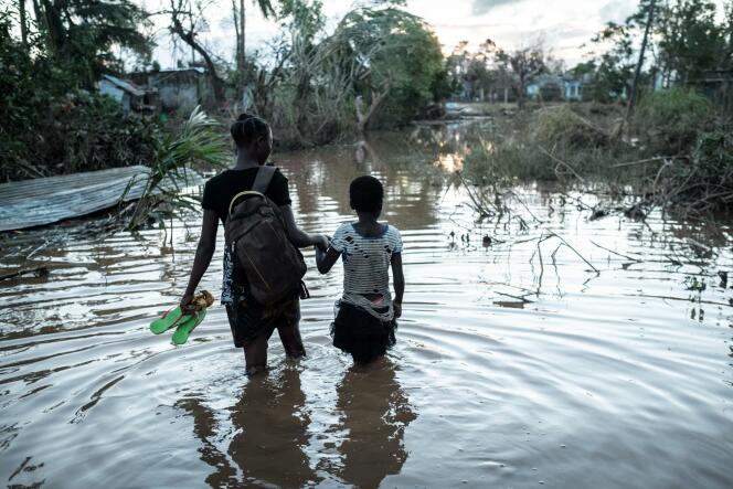 Rosita Zacarias (à gauche), âgée de 15 ans, tient sa jeune soeur de 9 ans, Joaninha, dans les eaux des inondations provoquées par le cyclone Idai, qui a détruit leur maison. Dans le district de Buzi, au Mozambique, le 22 mars 2019.