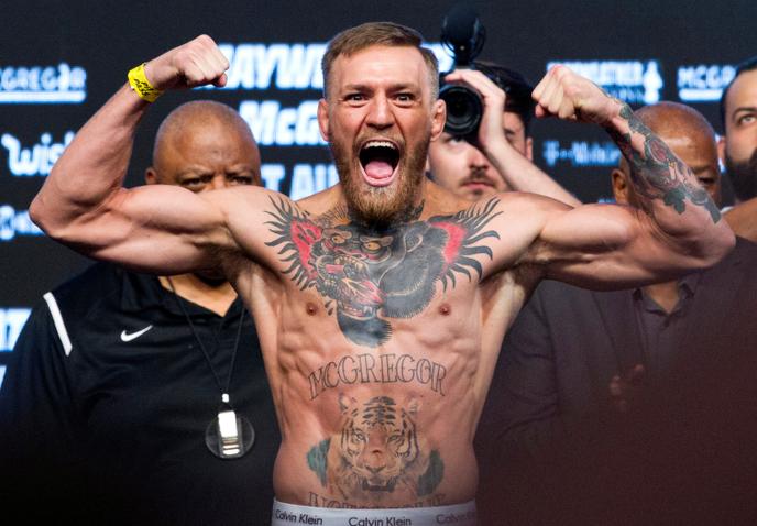 Conor McGregor pose sur la balance lors de sa pesée officielle avant son combat contre Floyd Mayweather, à Las Vegas, le 25 août 2017.