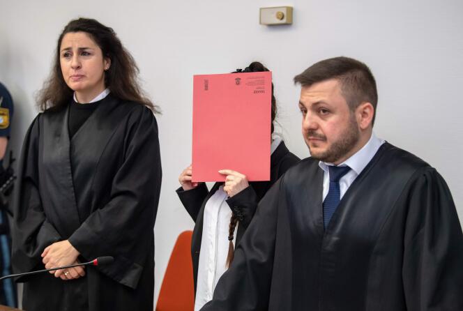 L’accusée, Jennifer Wenisch, se cache le visage derrière une chemise aux côtés de ses avocats, alors qu’elle arrive au tribunal pour l’ouverture de son procès le 9 avril 2019, à Munich (Allemagne).
