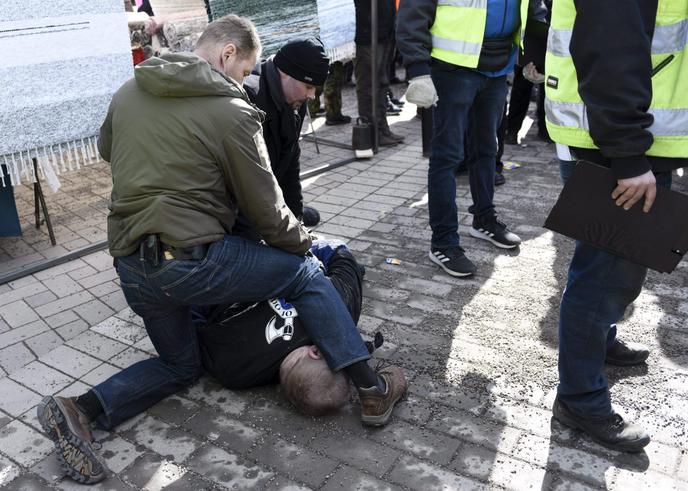 Des agents de sécurité maîtrisent un membre des Soldats d’Odin, un groupe d’extrême droite, en marge d’un meeting de campagne de Timo Soini, à Vantaa, en Finlande, le 24 mars.