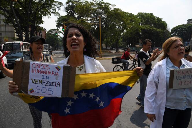 Une supportrice du président par intérim autoproclamé Juan Guaido lors d’une manifestation à Caracas, au Venezuela. Sur sa pancarte, on peut lire « Crise humanitaire au Venezuela, SOS ».