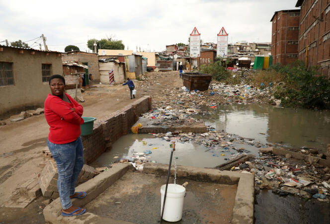 Une femme puise de l’eau dans le township d’Alexandra, à Johannesburg, en Afrique du Sud, le 10 avril.