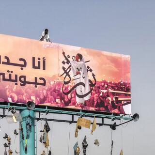A picture taken during anti-regime protests on April 11, 2019 shows a huge billboard bearing an image of Alaa Salah, a Sudanese woman propelled to internet fame earlier this week after clips went viral of her leading powerful protest chants against Sudan's president, in the Sudanese capital Khartoum. Arabic writing next to her photo in a white gown reads: 