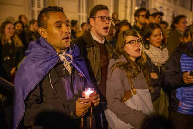 Un groupe de chrétiens prie et chante devant l'incendie de la cathédrale Notre-Dame de Paris, le 15 avril.