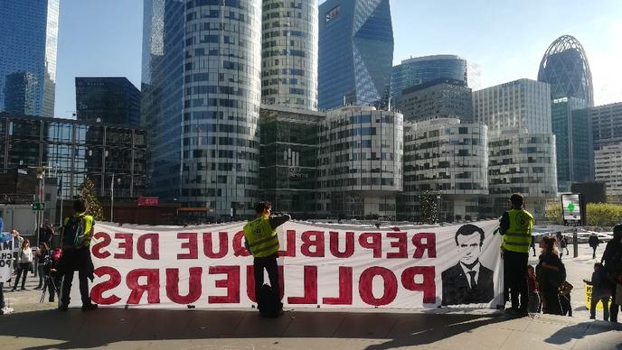 Desde as 8h30 de sexta-feira, 19 de abril, os ativistas Greenpeace, ANV-COP21 e Amigos da Terra bloqueiam todo o acesso à Torre Total em La Défense.  Eles denunciam "Macron o presidente dos poluidores".