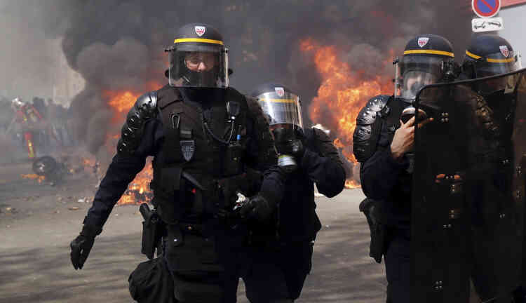 Des policiers à proximité de véhicules incendiés lors de la manifestation des « gilets jaunes », le 20 avril.