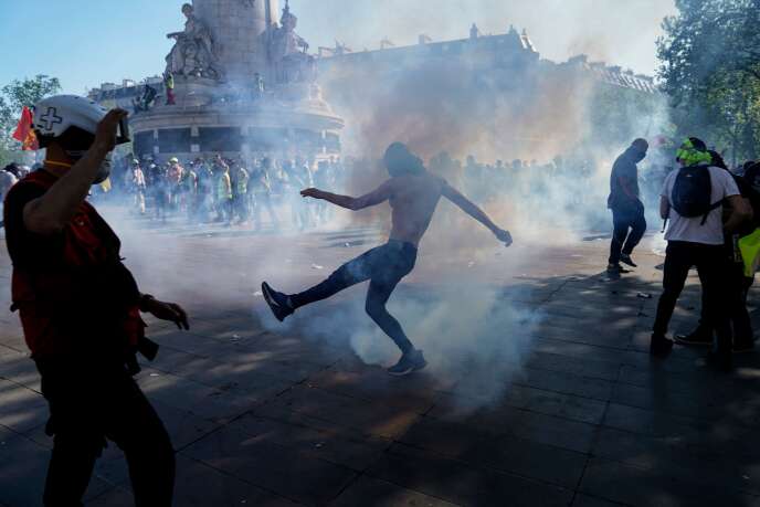 Un manifestant repousse une cartouche de gaz lacrymogène lors de la manifestation des « gilets jaunes », place de la République, à Paris, le 20 avril.