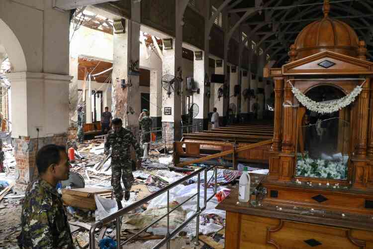 Des soldats sri-lankais enjambent des corps recouverts par des couvertures au sein de l’église de Saint Antoine à Colombo.  Le premier ministre Ranil Wickremesinghe a condamné des « attaques lâches ».