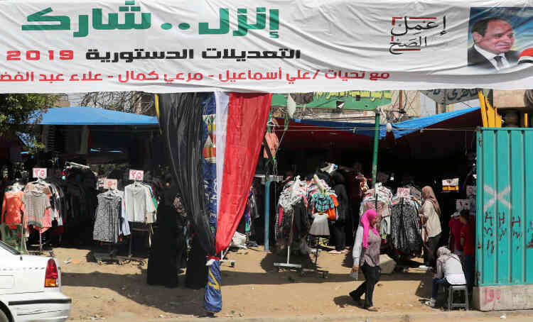 Une bannière sur laquelle on peut lire « Va... Partage » devant un marché populaire au Caire, le 9 avril. Tous les moyens ont été déployés pour que la population se déplace massivement et coche la case « Je suis d’accord » sur les bulletins de vote. Dans les rues égyptiennes, la loyauté s’affiche avec des banderoles.