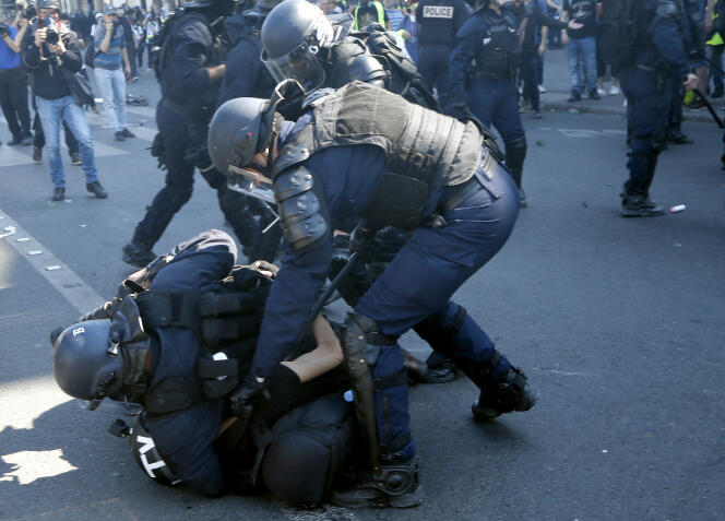 La police met à terre un cameraman, place de la République, lors de la manifestation parisienne des « gilets jaunes », le 20 avril.