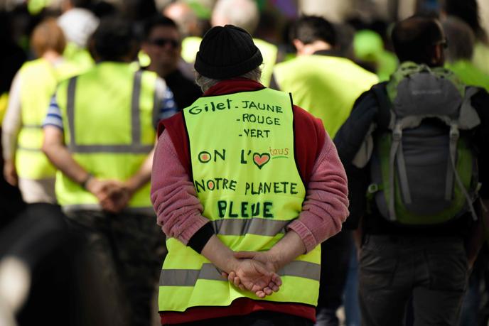 Un manifestant porte un gilet jaune sur lequel est écrit : « Gilet jaune, rouge ou vert, nous aimons tous notre planète bleue », lors d’une manifestation, le 27 avril 2019, à Marseille.