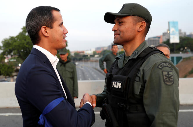 Le leader de l’opposition à Maduro, Juan Guaido, serre la main à un militaire près de la base aérienne La Carlota, à Caracas, le 30 avril 2019.