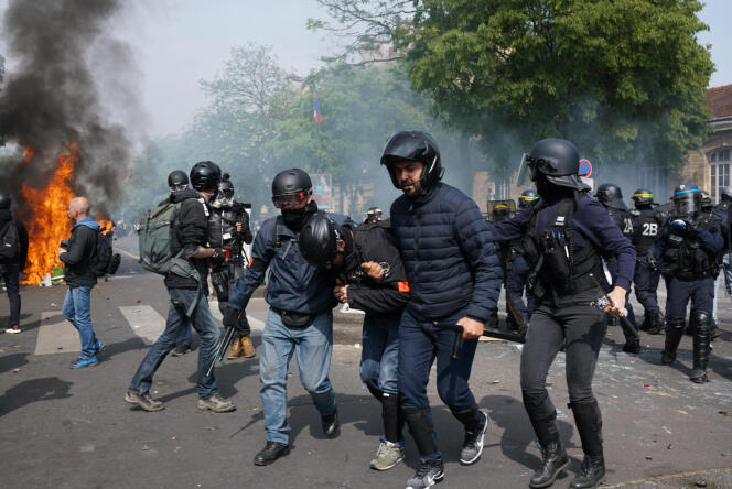 Un policier blessé est évacué par ses collègues boulevard de l’Hôpital, lors de la manifestation du 1er-Mai à Paris.