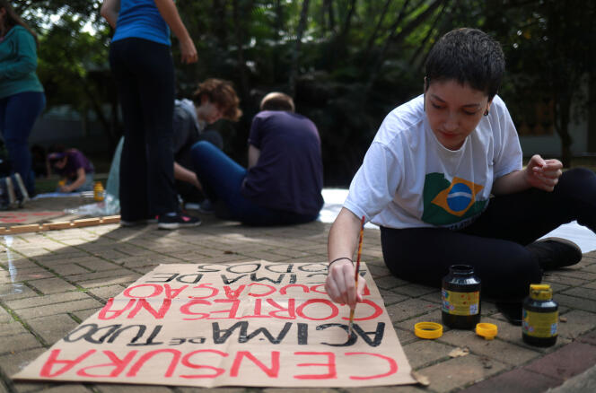 Une étudiante de Sao Paulo prépare une pancarte avant de se rendre à une manifestation contre les réductions prévues des budgets de l’enseignement supérieur au Brésil, le 15 mai 2019.