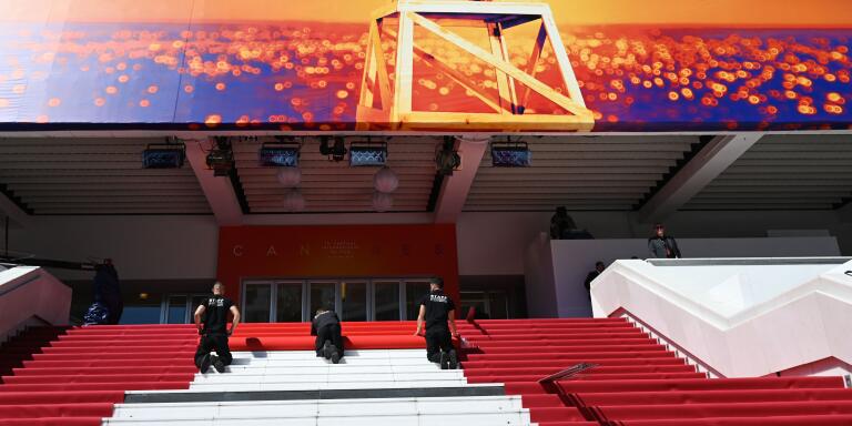 Staff members install the red carpet outside the festival palace on May 14, 2019 ahead of the opening of the 72nd edition of the Cannes Film Festival in Cannes, southern France. / AFP / Christophe SIMON

