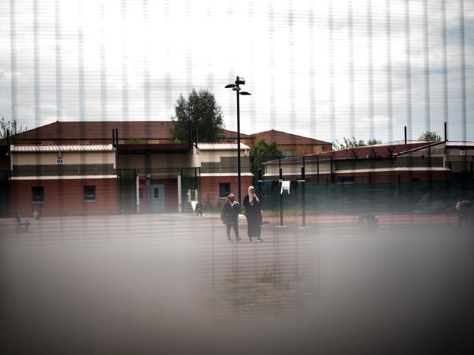 Des retenus marchent dans la zone de vie lors d'une visite.