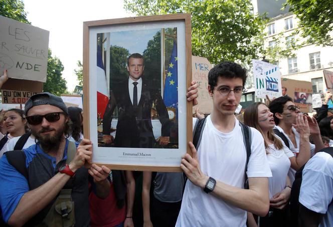 Des activistes brandissant un portrait d’Emmanuel Macron lors d’une marche pour le climat à Paris, le 24 mai 2019, afin de protester contre l’inaction climatique du président de la République.