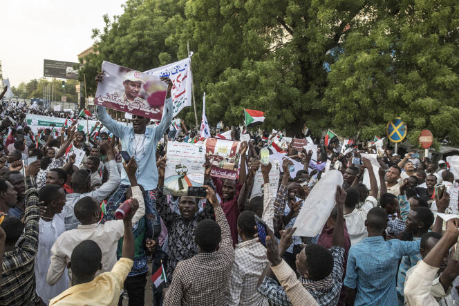 Des manifestants venus de régions rurales brandissent les photos des deux principales figures de l’armée soudanaise.