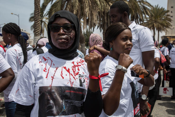 Une manifestante proteste contre les violences faites aux femmes, le visage couvert de fausses cicatrices, le 25 mai 2019 à Dakar.