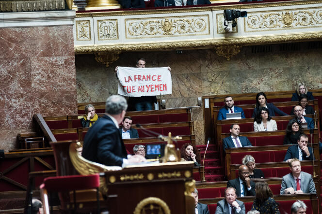 Le député Sébastien Nadot (non-inscrit) brandit une pancarte lors des questions au gouvernement, à l’Assemblée nationale à Paris, le 19 février.